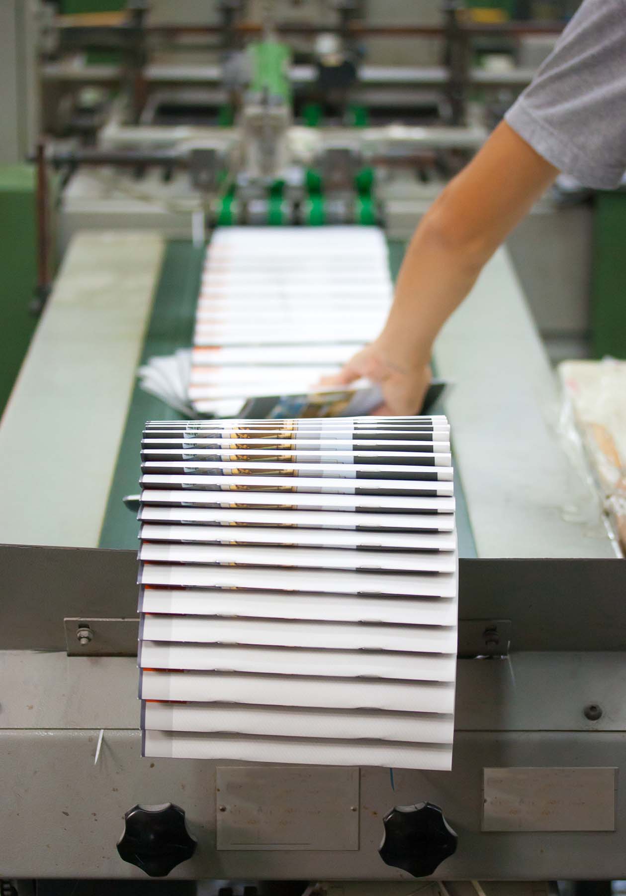 Picture of a finishing press with printed booklets on it